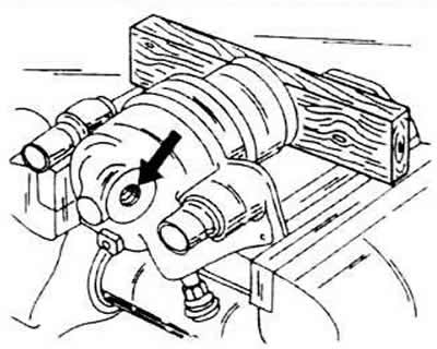 Zaciśnij cylinder w imadle i zdejmij pierścień przeciwpyłowy z cylindra i tłoka (śrubokrętem).
