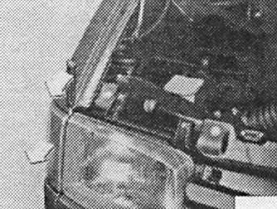18. Vložte skrutkovač zhora medzi svetlomet a puzdro smerového svetla. Zaisťovací jazýček sa ohne…